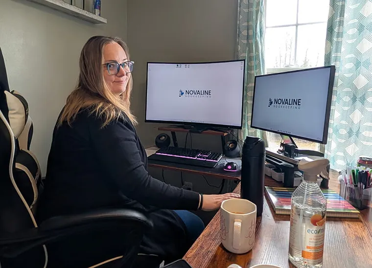A business owner reviewing paperwork with a laptop nearby.